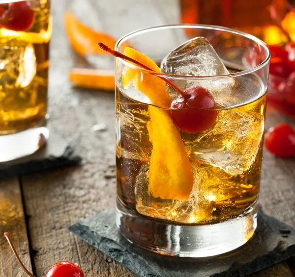 Homemade Old Fashioned Cocktail with Cherries and Orange Peel